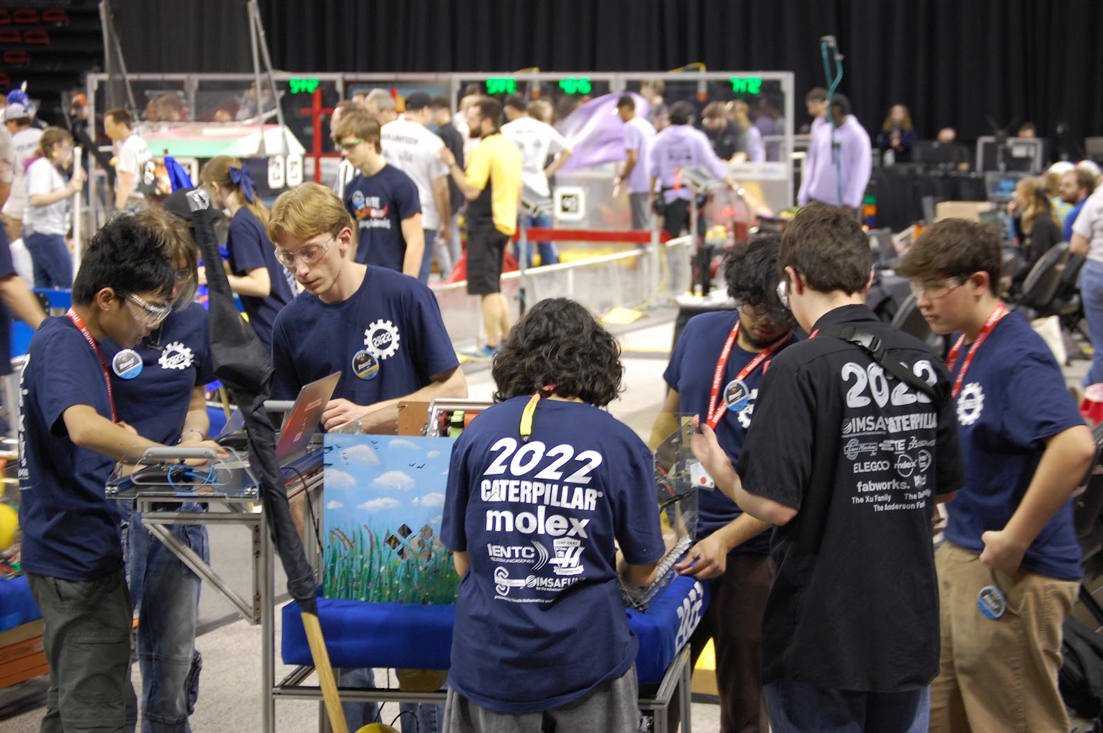 Drive team huddled around the robot on its cart, working, 2025–26 season.