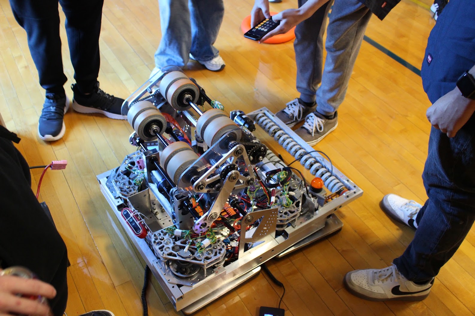 Robot without bumpers at week zero with team members around it, 2023–24 season.