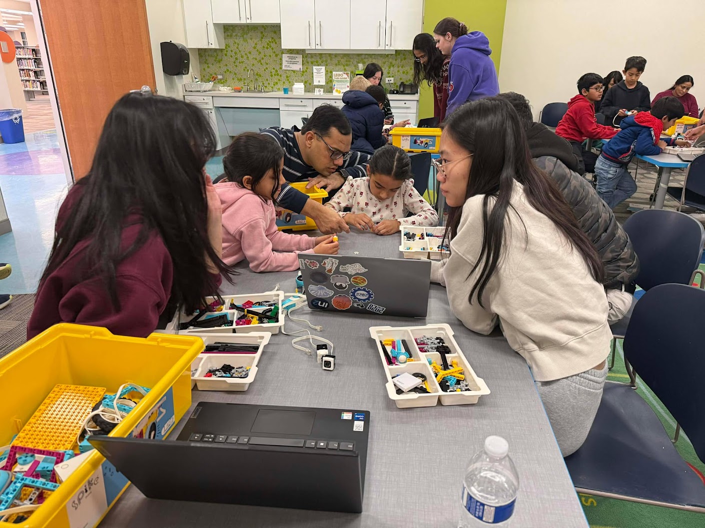 Team members helping kids build with SPIKE kits.